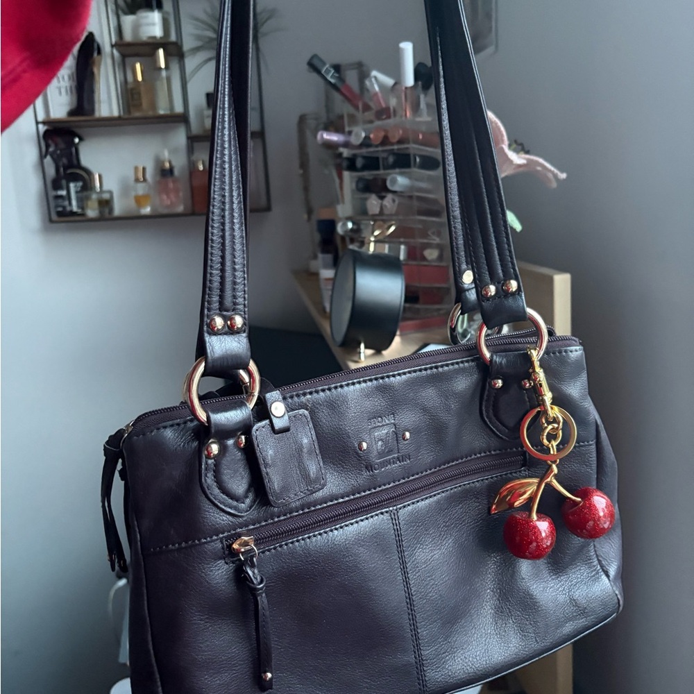 Brown leather bag with gold hardware and cherry charm